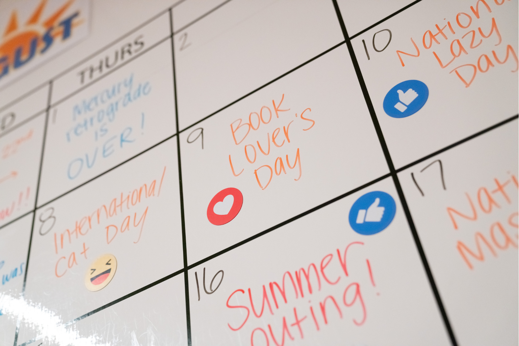 Image of a whiteboard calendar with events and magnets on it