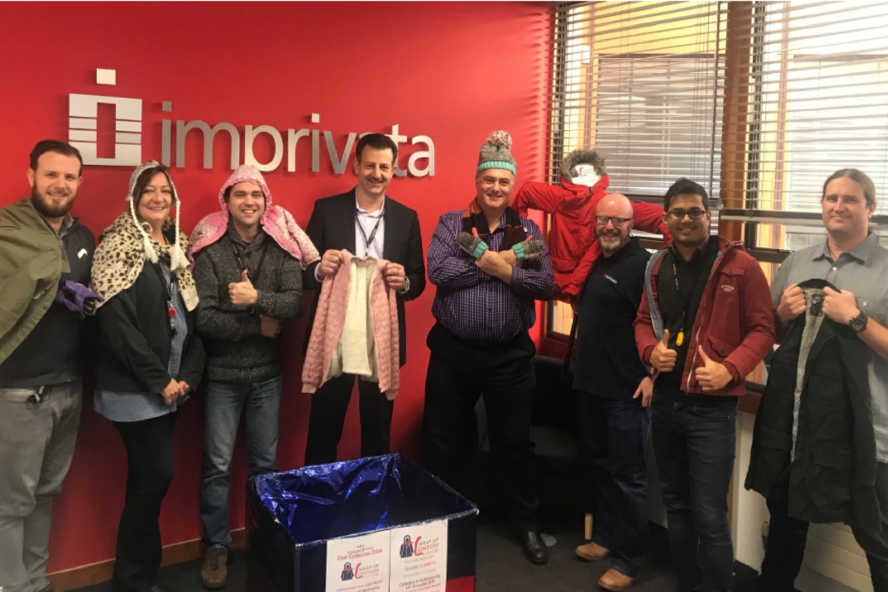 Image of a group of employees holding their donations for a clothing drive