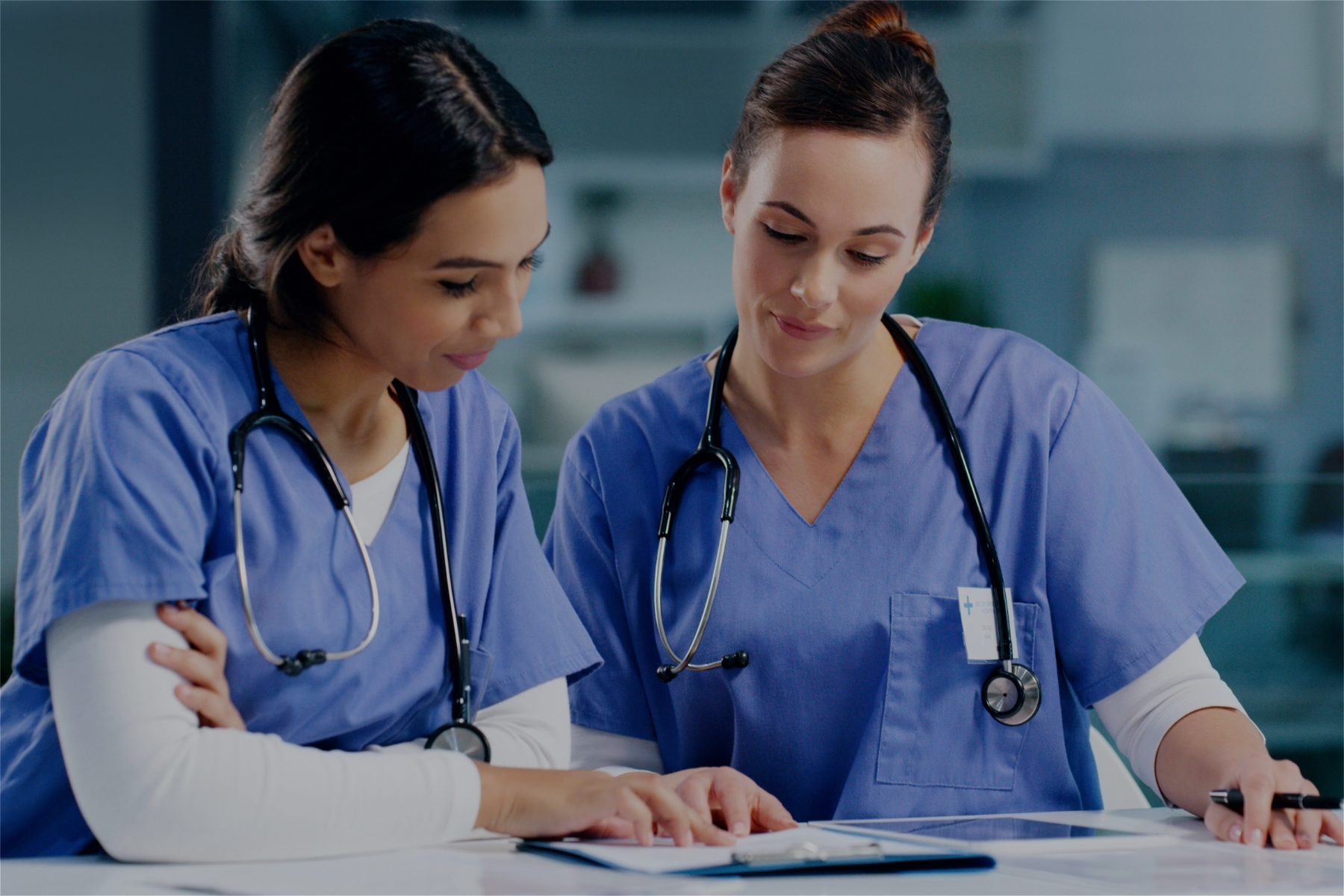 Image of two nurses reading a clipboard