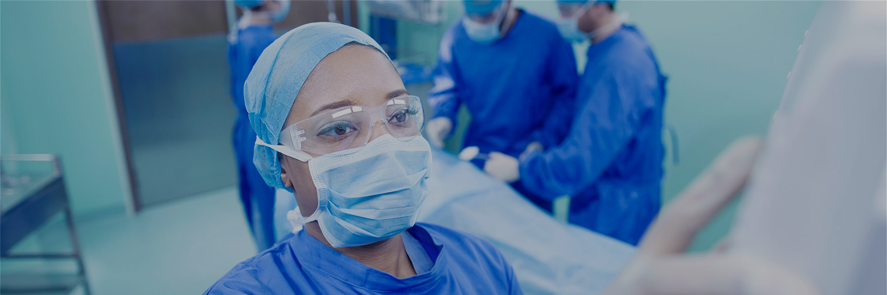 Image of a surgeon in an operating theater with their hand on a medical device 