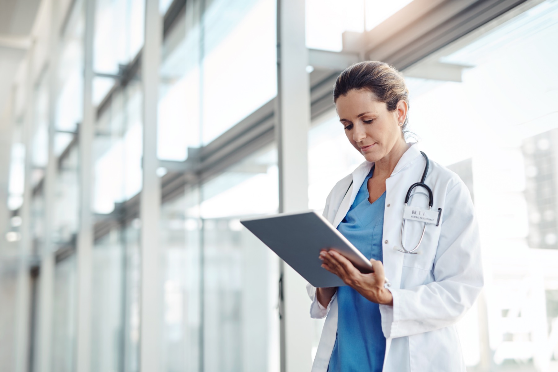 Image of a doctor looking at a smart tablet and smiling