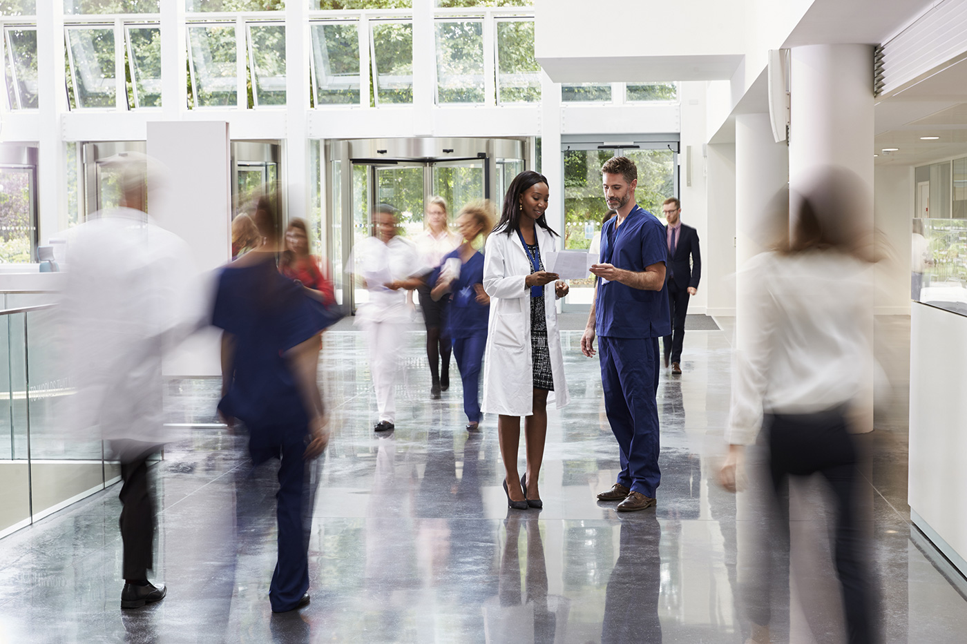 Image of two doctors talking in a crowded lobby