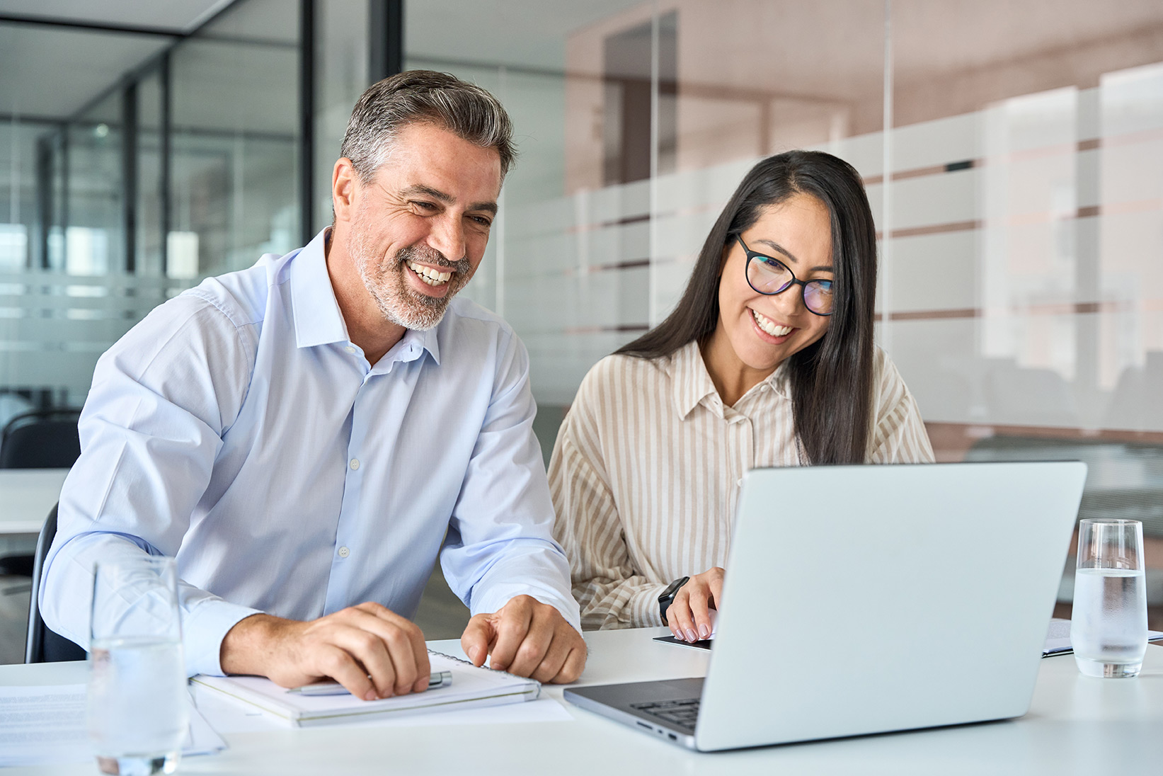 Image of two happy people viewing a laptop