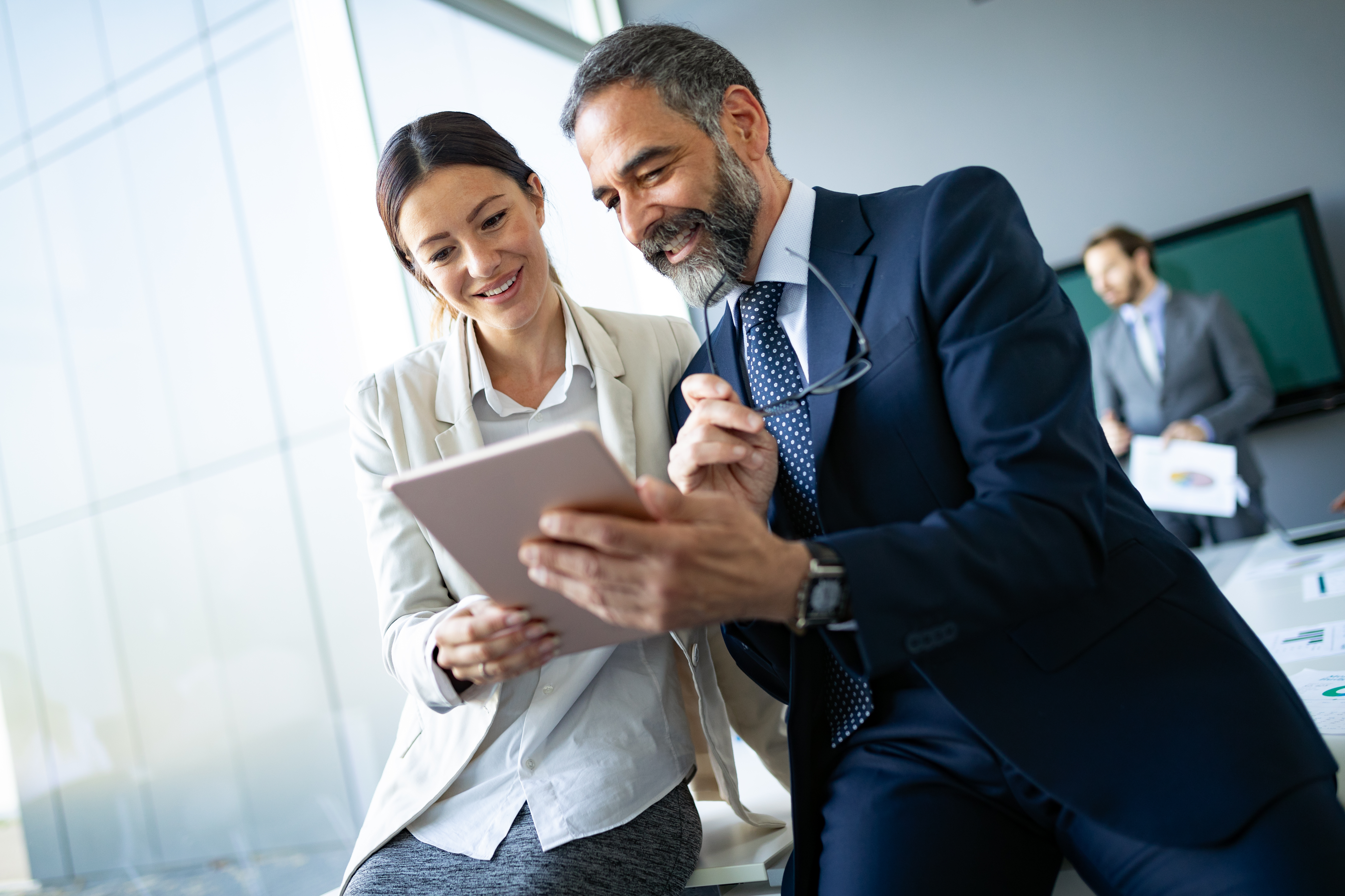 Two corporate employees viewing a tablet