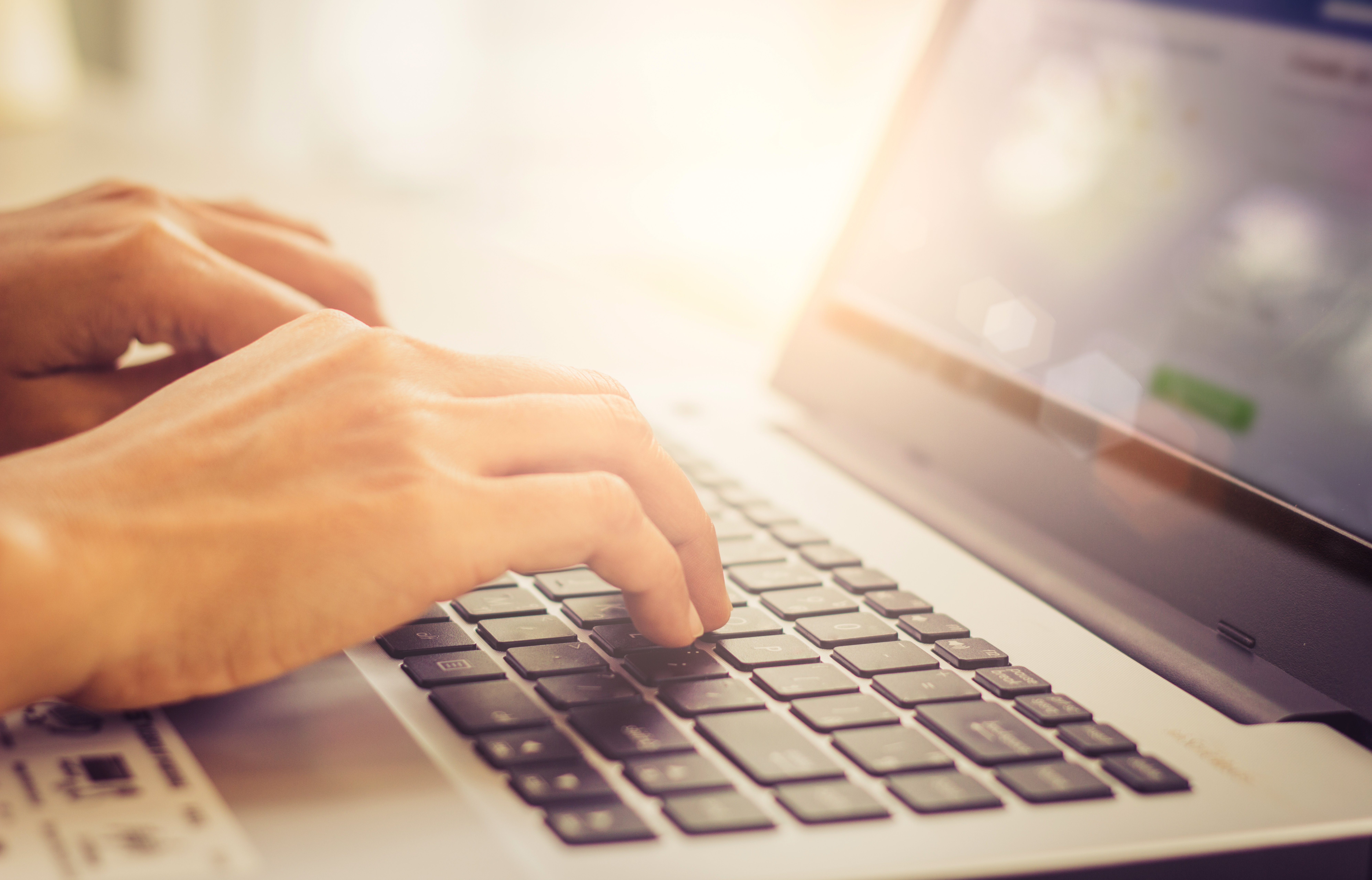 Photo of hands typing on a laptop