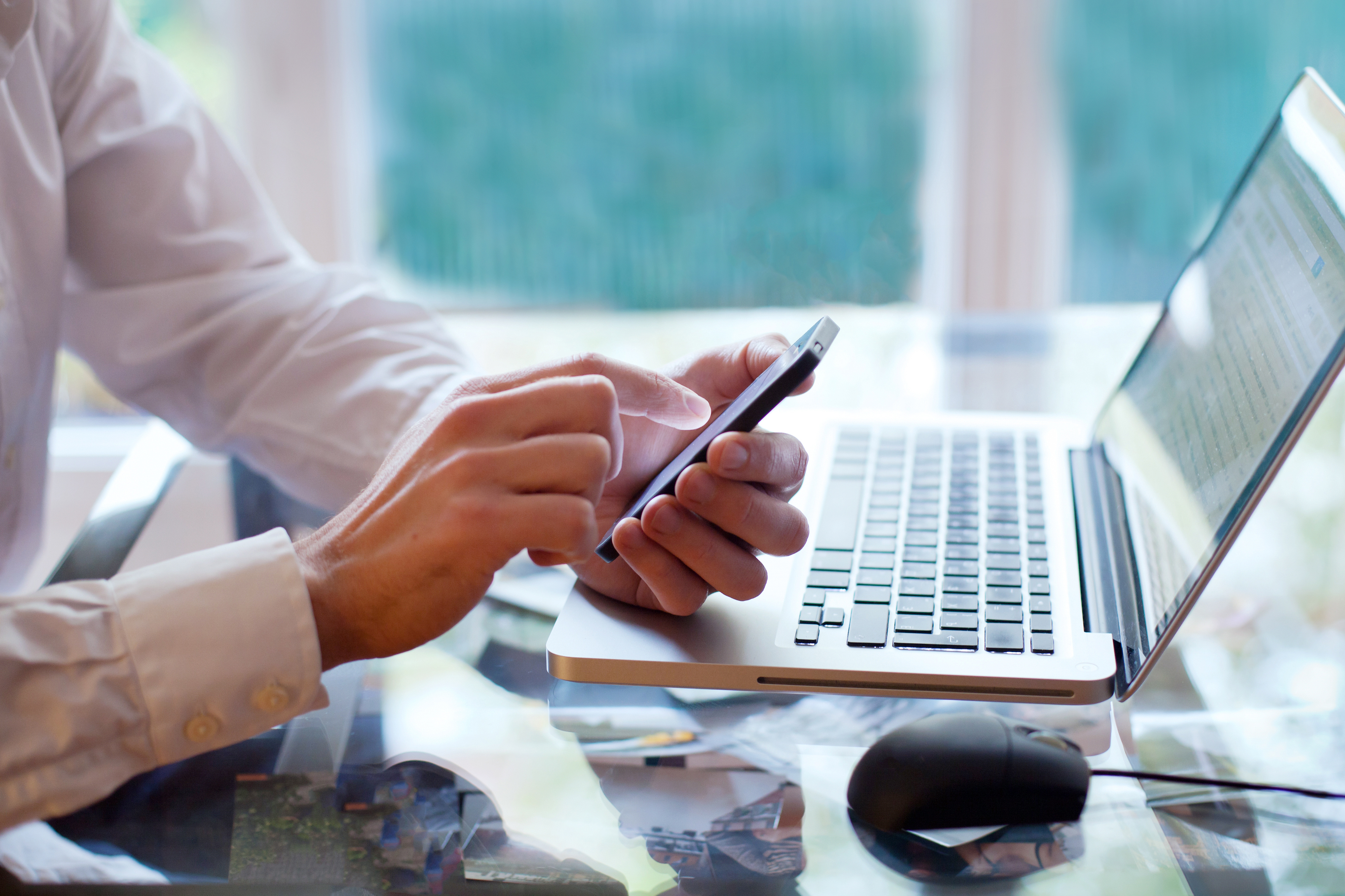 Photo of business person using iPhone at desk