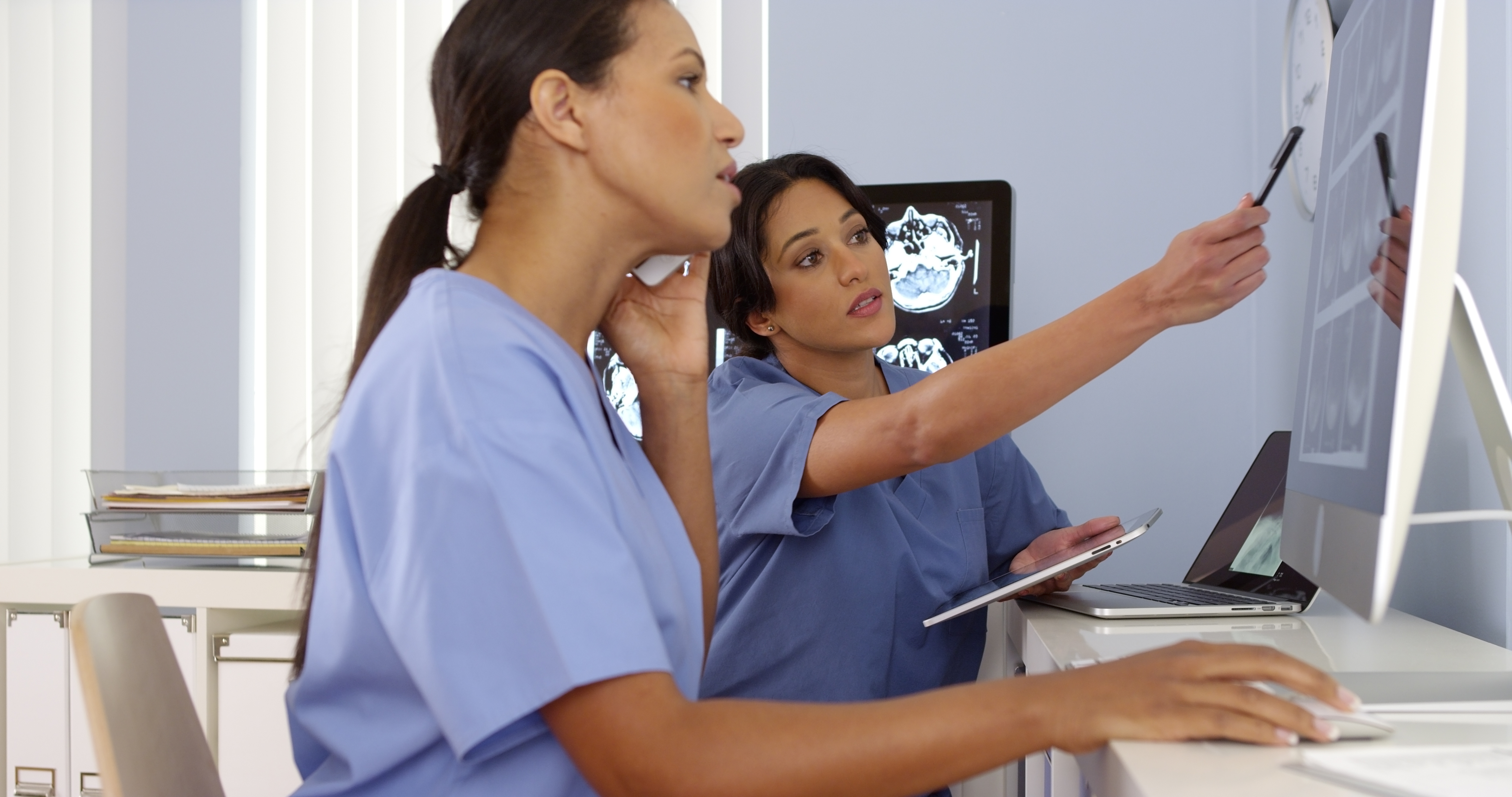 Photo of two doctors working on mobile devices