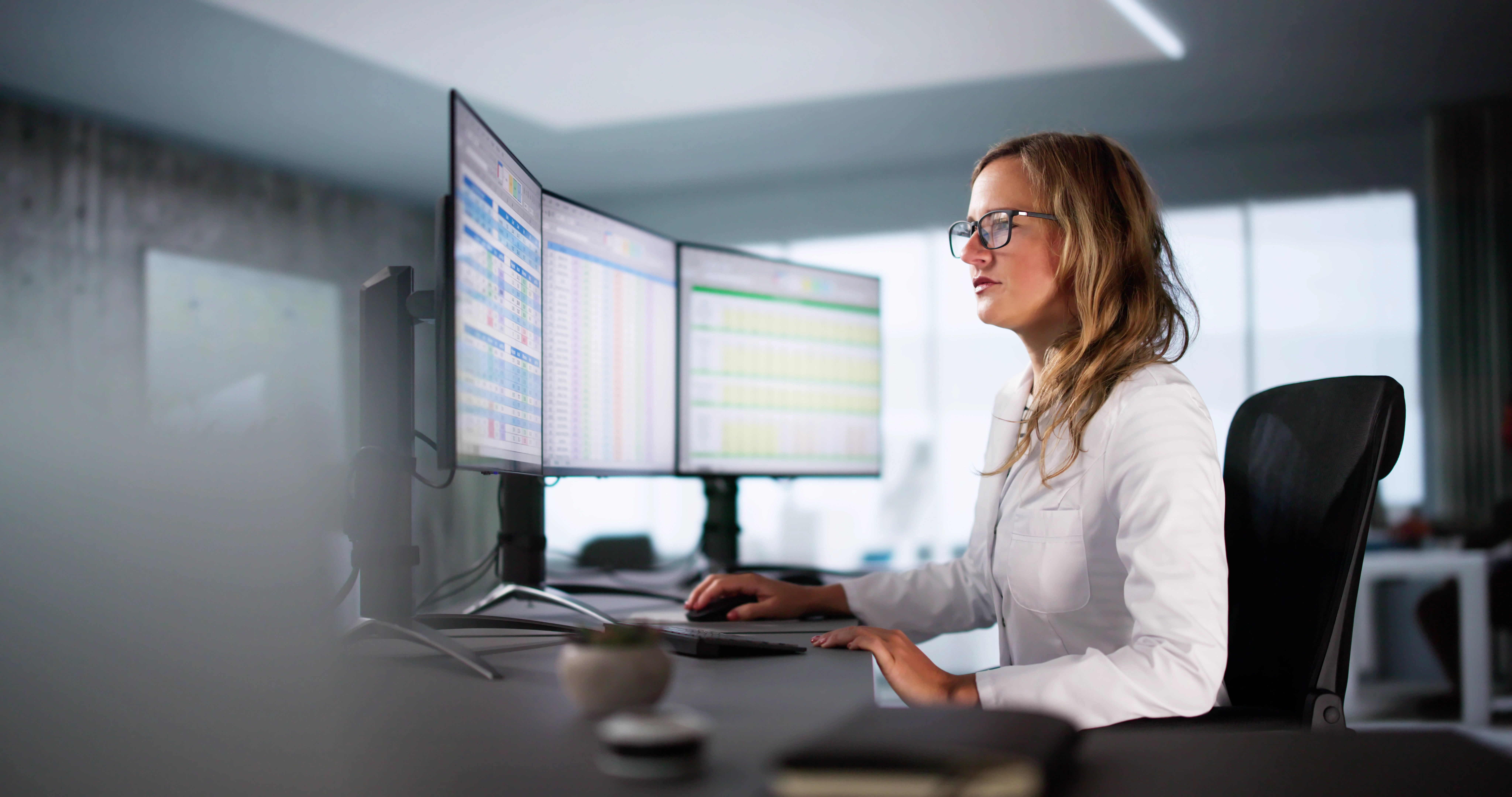 Photo of woman using a computer and monitors