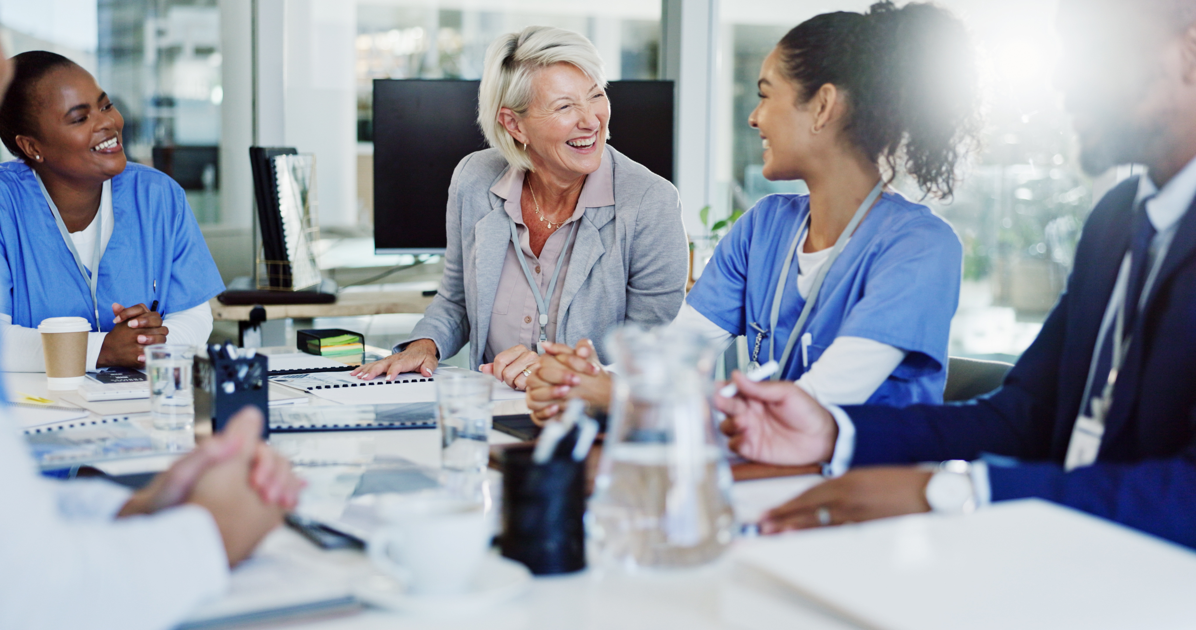Nurses and administrators speaking to each other at a table