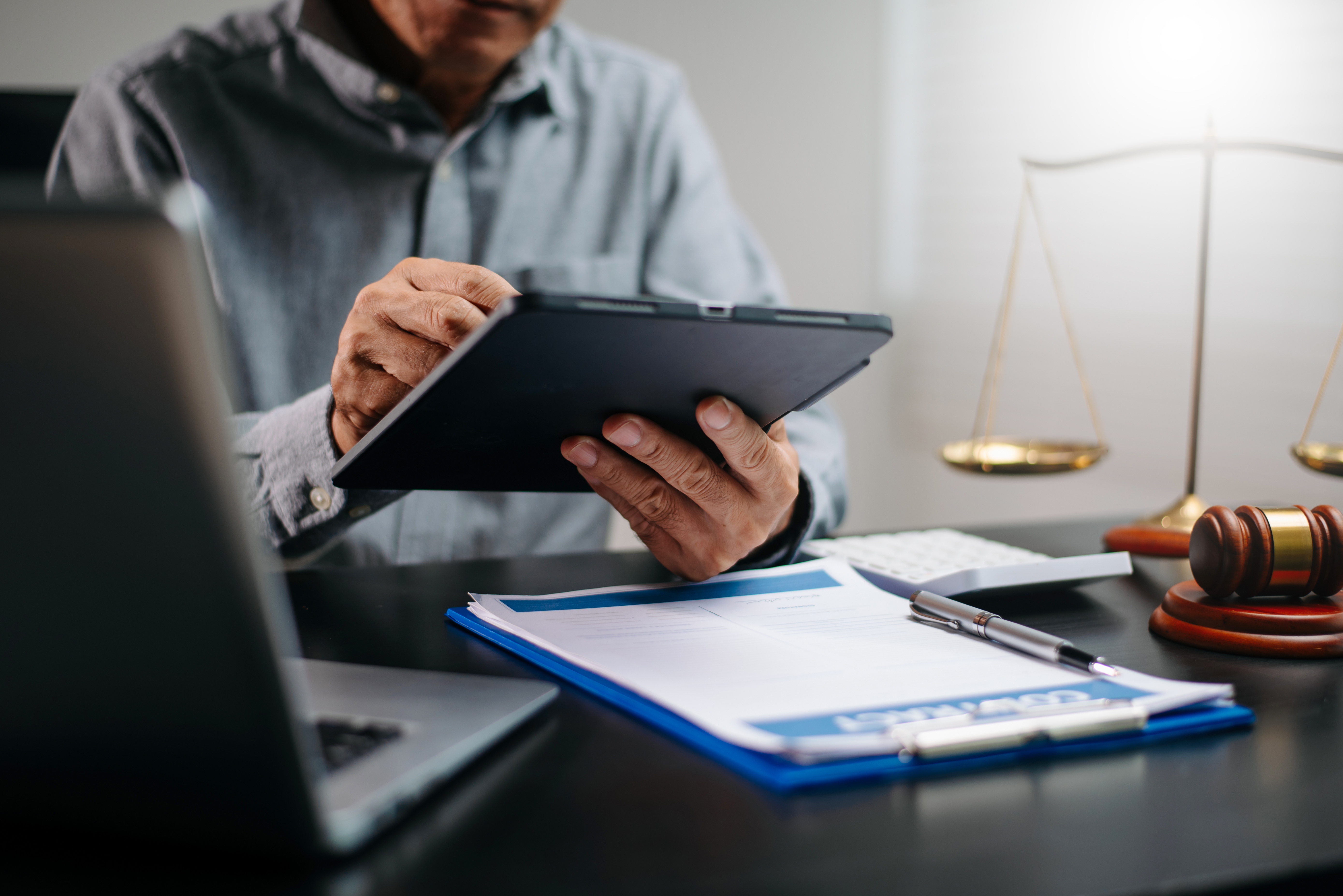 Photo of lawyer using tablet to share data