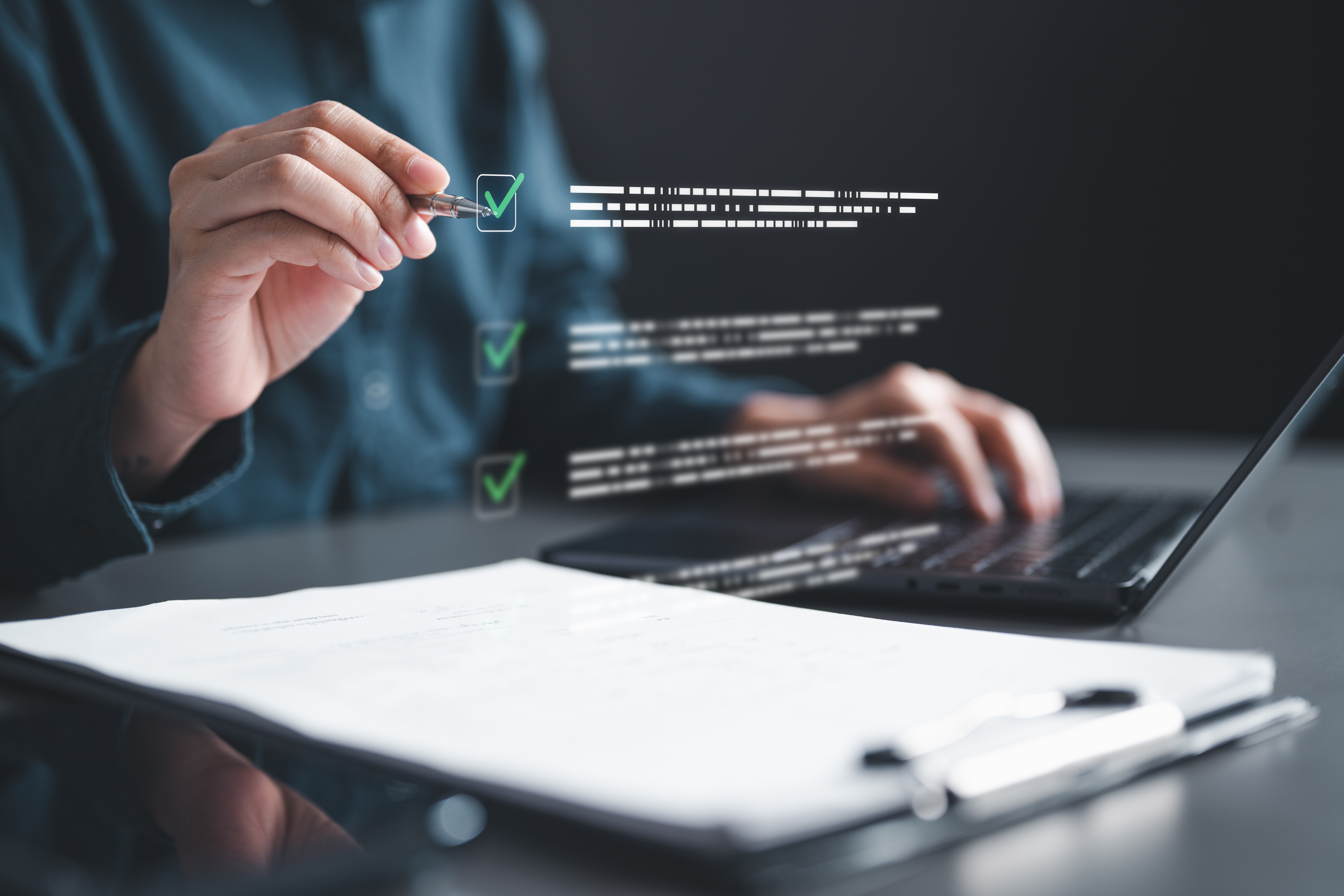 Person ticking boxes on a digital checklist while working on a laptop