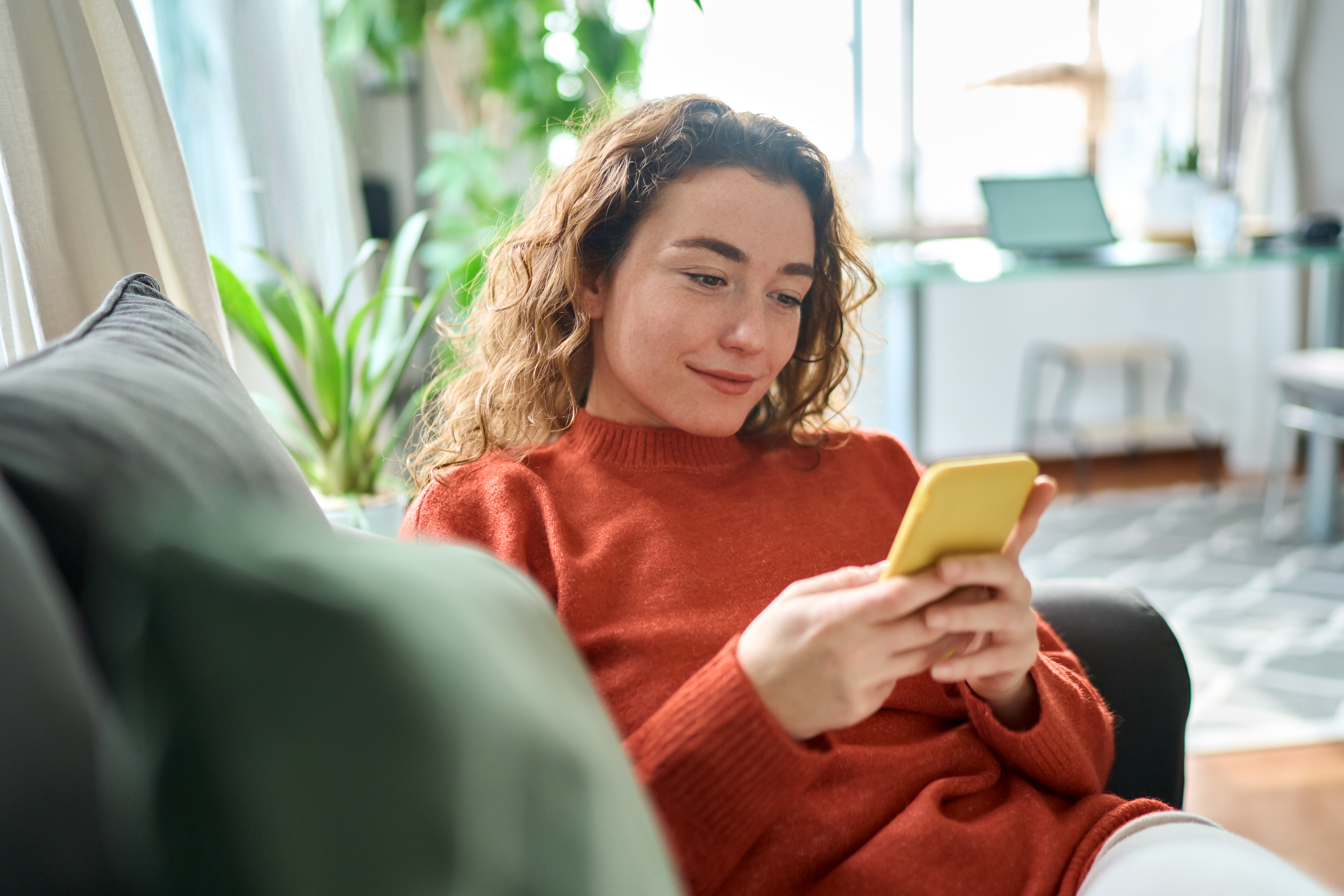 Photo of woman at home using mobile device to use patient portal