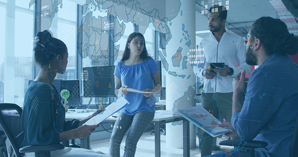 Team of employees discussing a presentation, representing shared workflows and MFA account-sharing workarounds