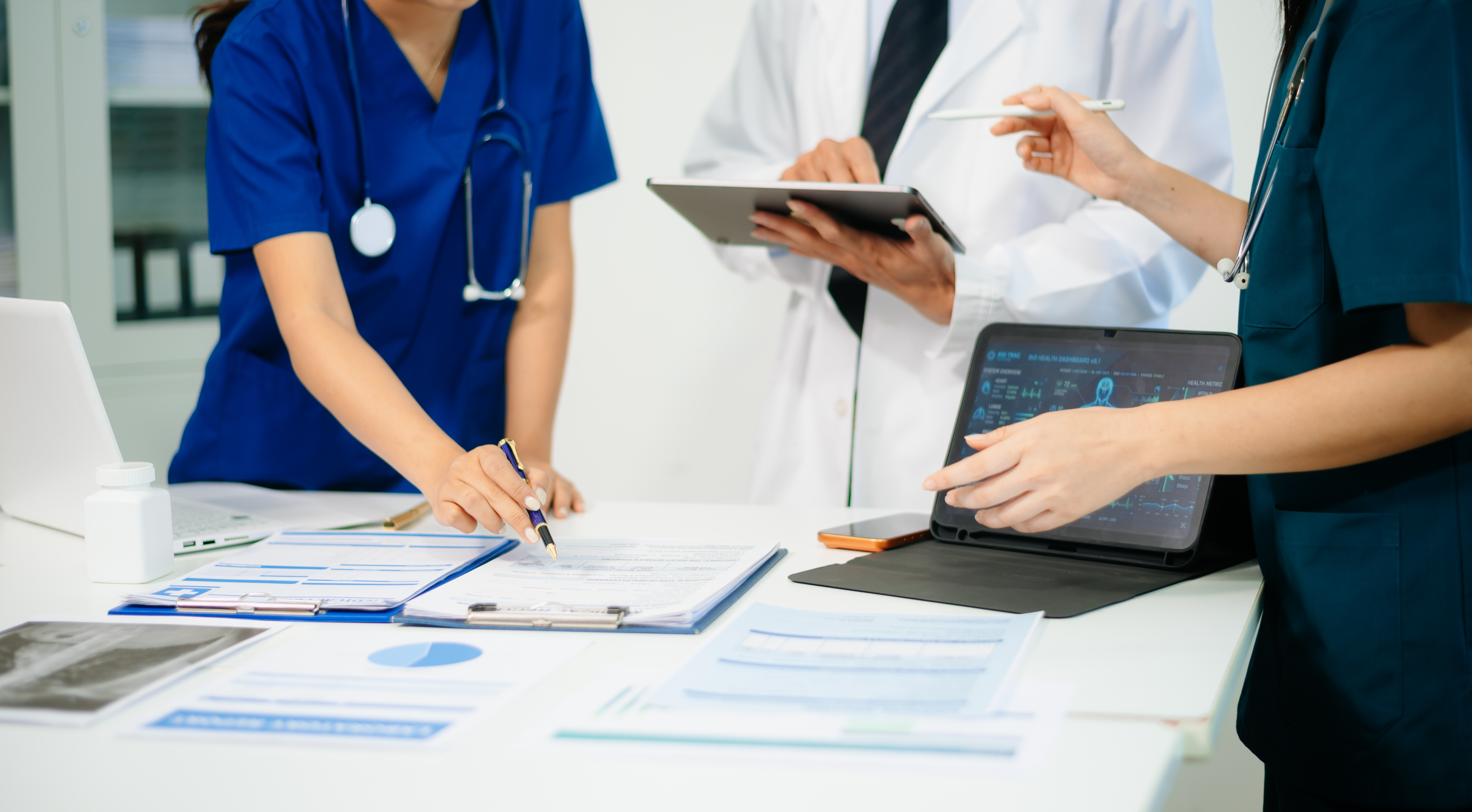 Healthcare workers at desk looking at paperwork